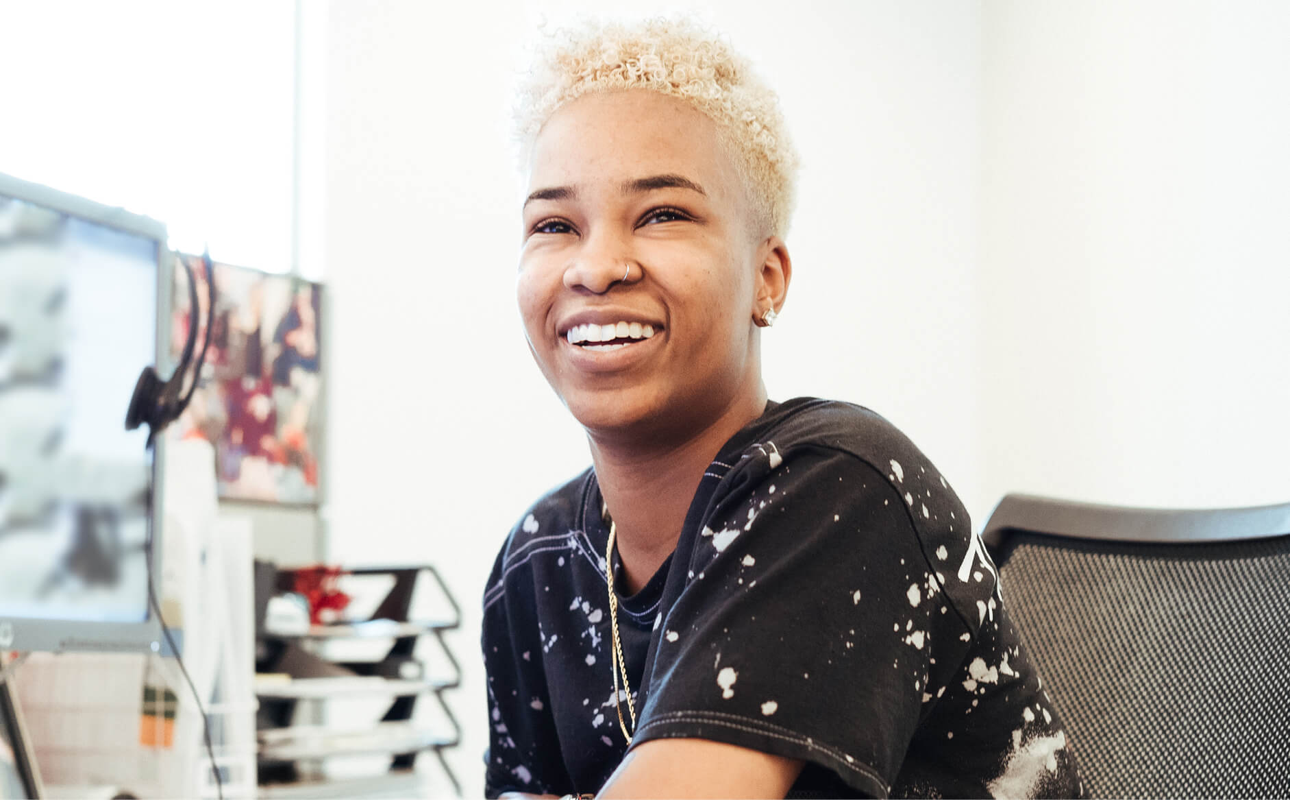 Capital One Customer Care associate sits at desk and smiles